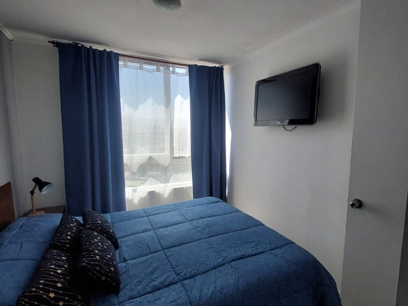 Dormitorio principal con ventanal y cortinas
