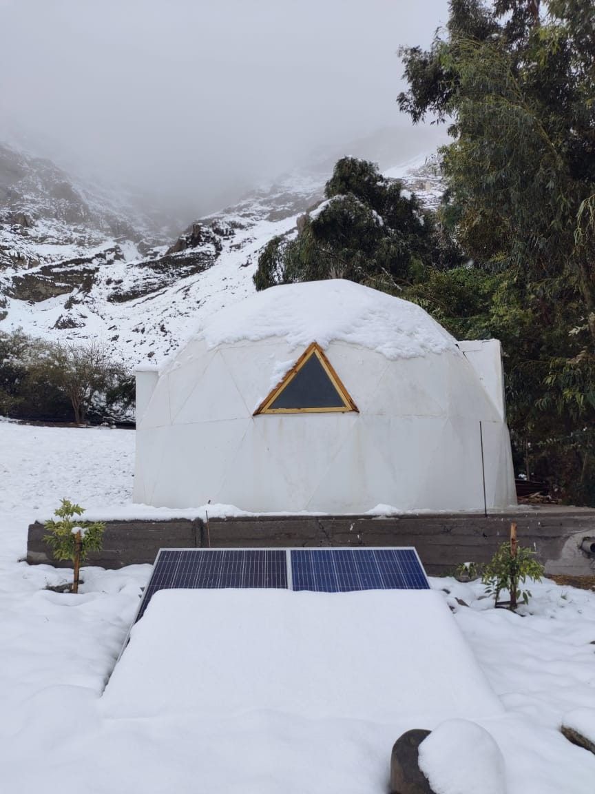 Domo blanco nevado con paneles solares al frente