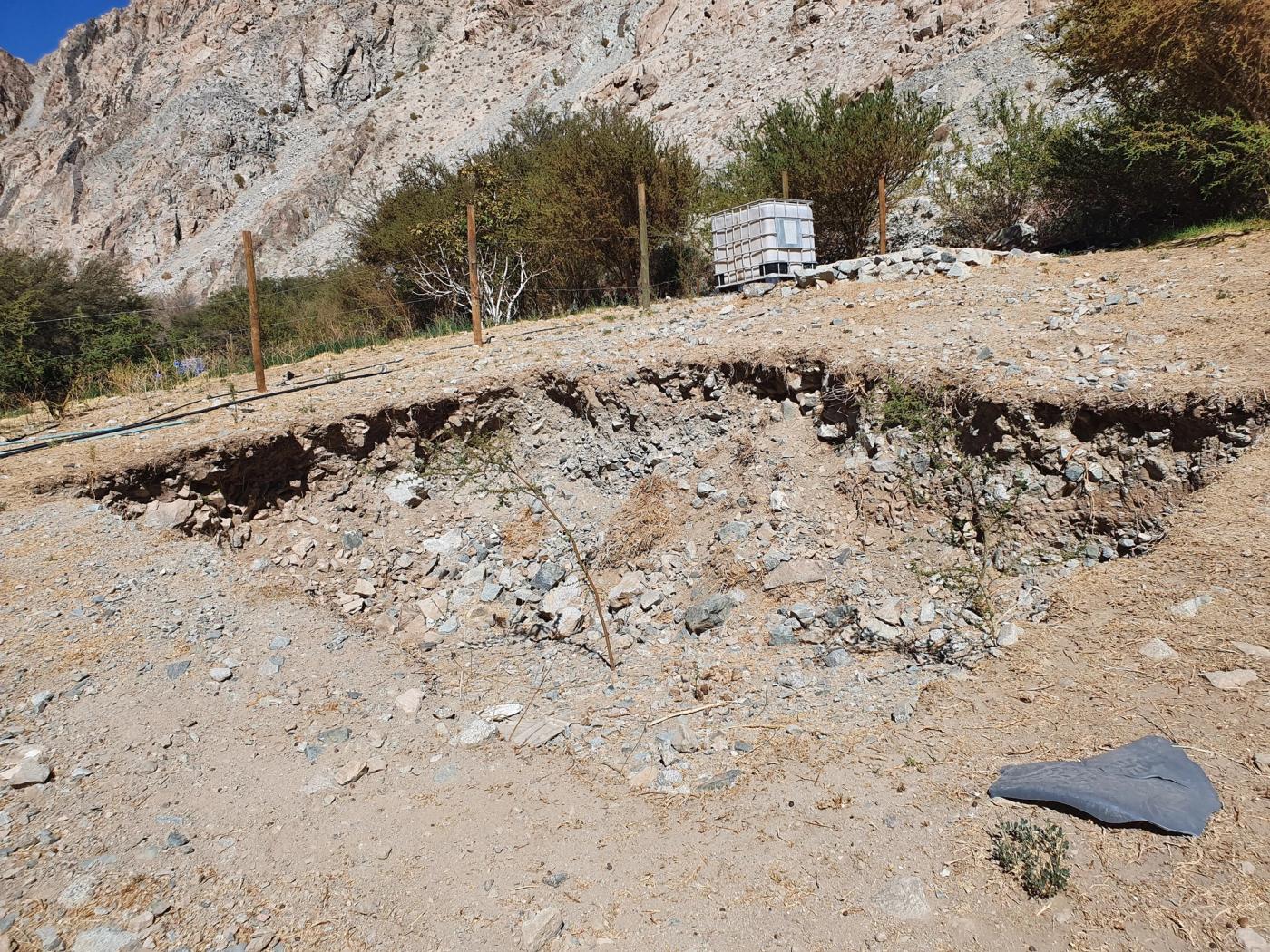Excavación en el terreno con estanque y postes de cerco