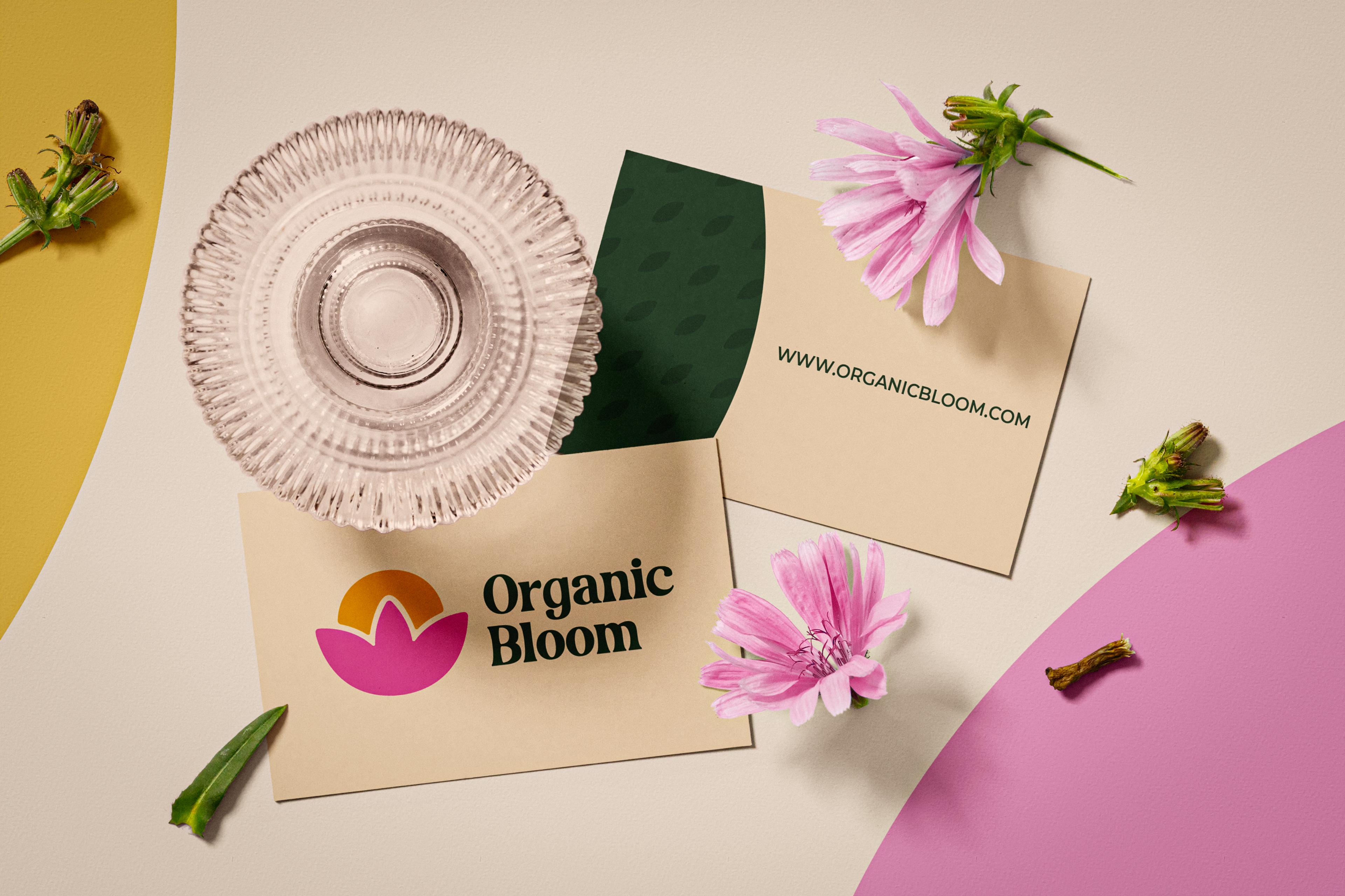 front and back side of Organic Bloom business cards on a table with flowers and a glass jar