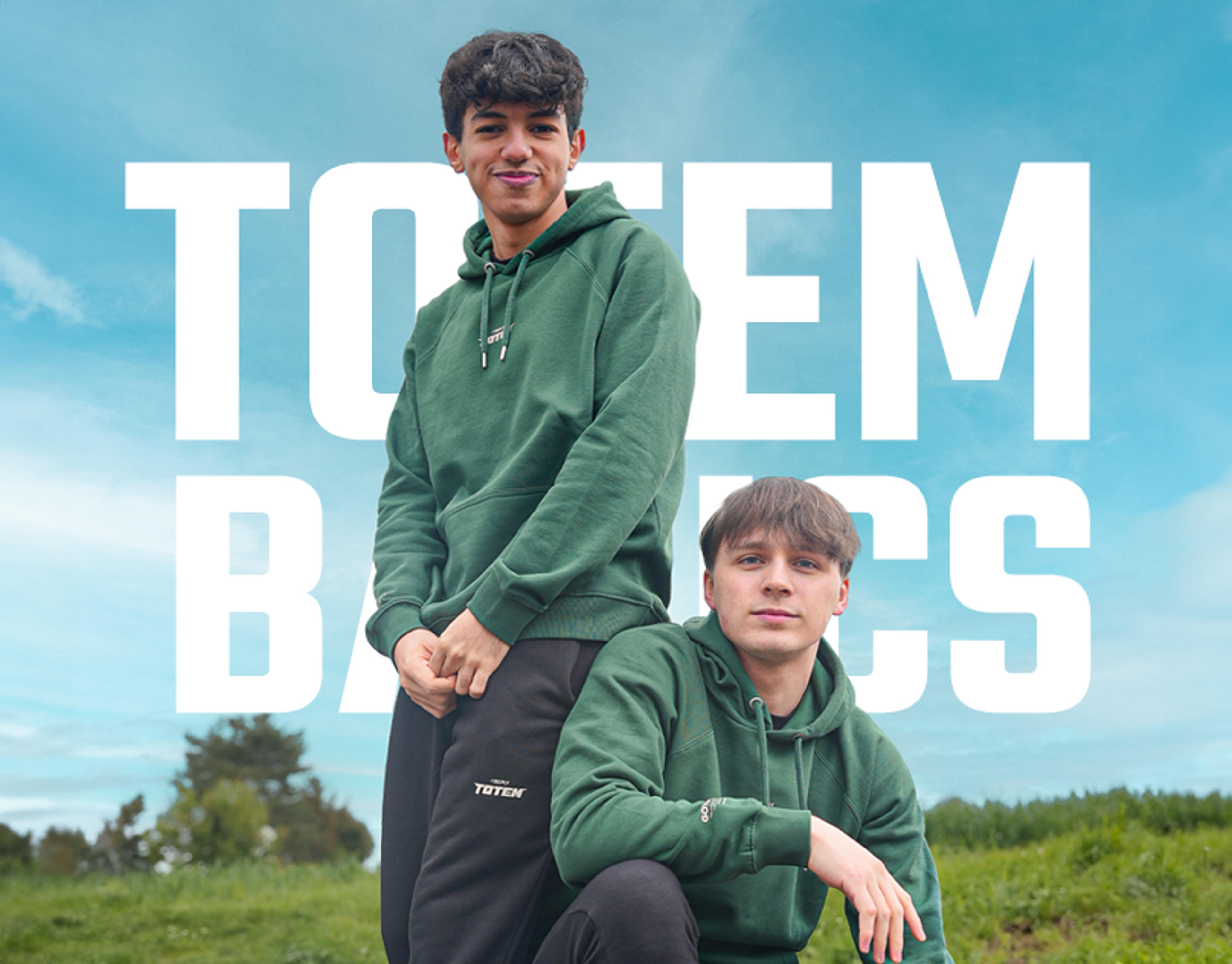 Maury and Maru on a sunny landscape wearing the "Totem Basics" collection, a green hoodie and black pants