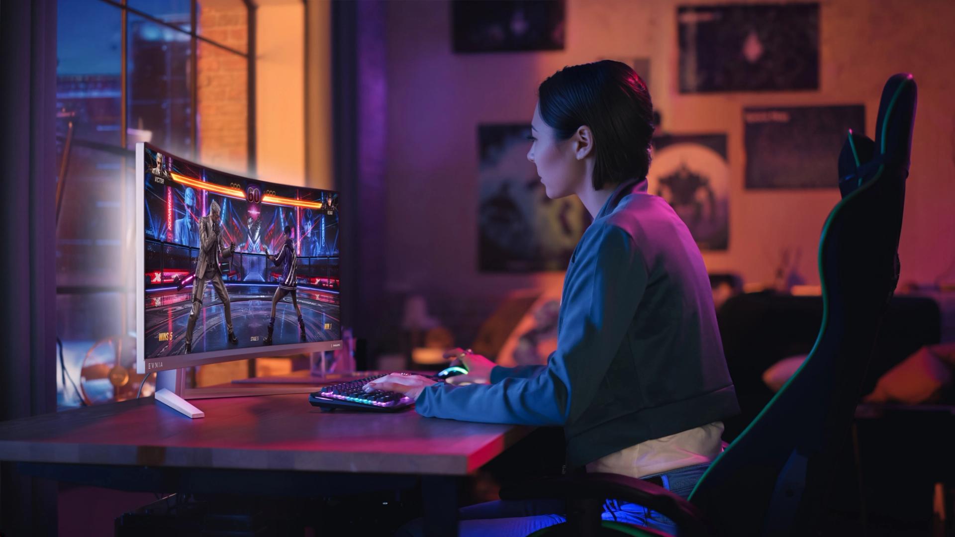 Woman gaming on a Philips Evnia 34M2C8600P curved ultrawide monitor in an Ambiglow-lit gaming setup.