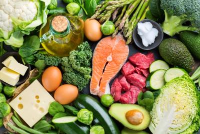A selection of real, low carbohydrate foods, including salmon, beef, cheese, eggs, and leafy green vegetables.