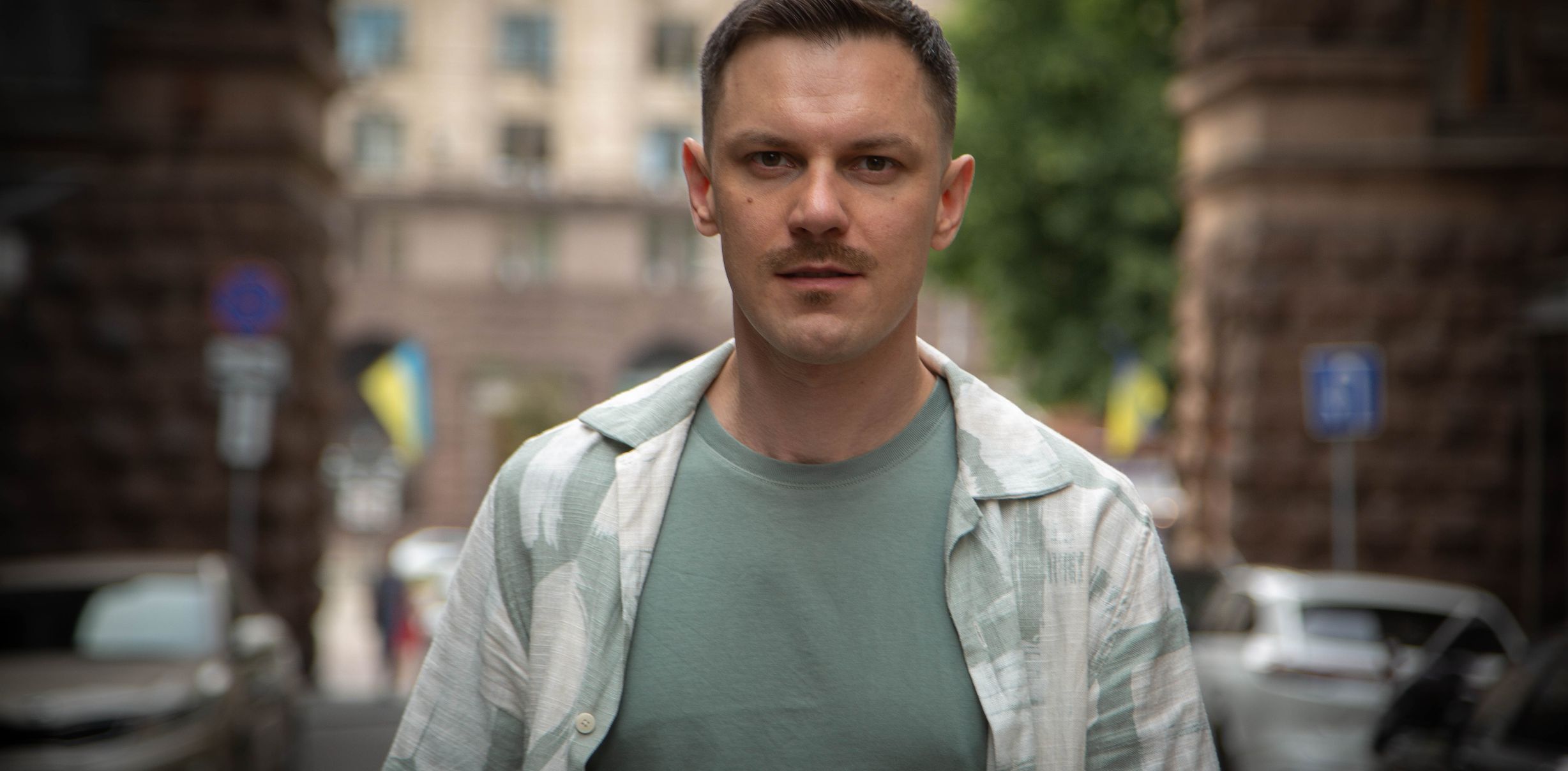 Максим Федоров стоит на улице на фоне зданий