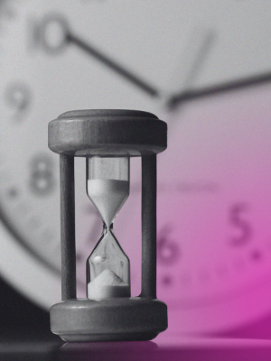 sand timer in front of wall clock