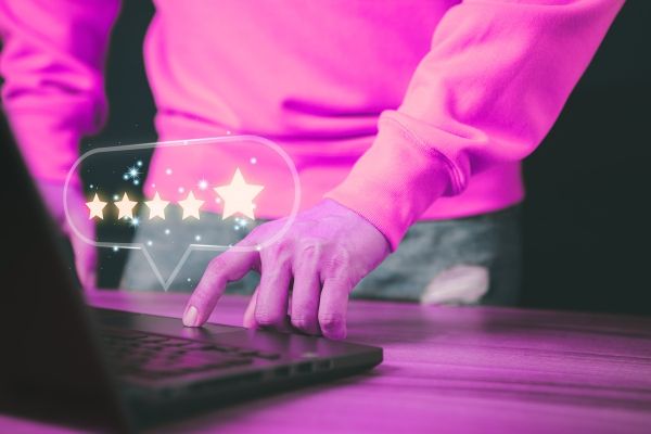 hands typing on a keyboard with a comment bubble that shows 5 stars