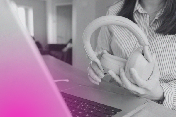 person holding headphones in front of laptop