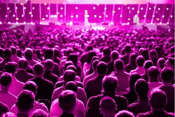audience overlooking a stage with a keynote speaker at a conference