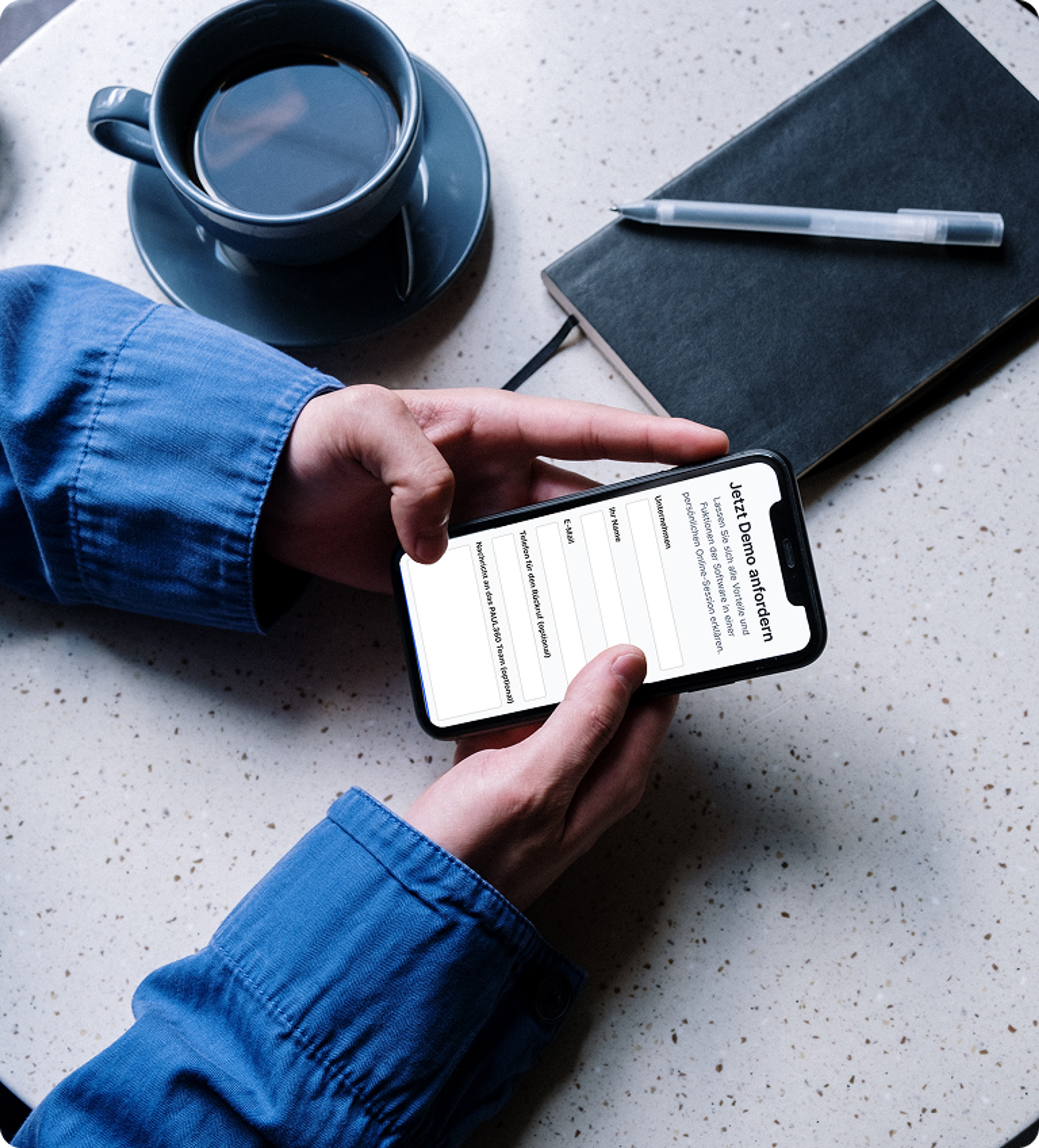 Person hält ein Smartphone mit Formular im Café, daneben Kaffee und Notizbuch.