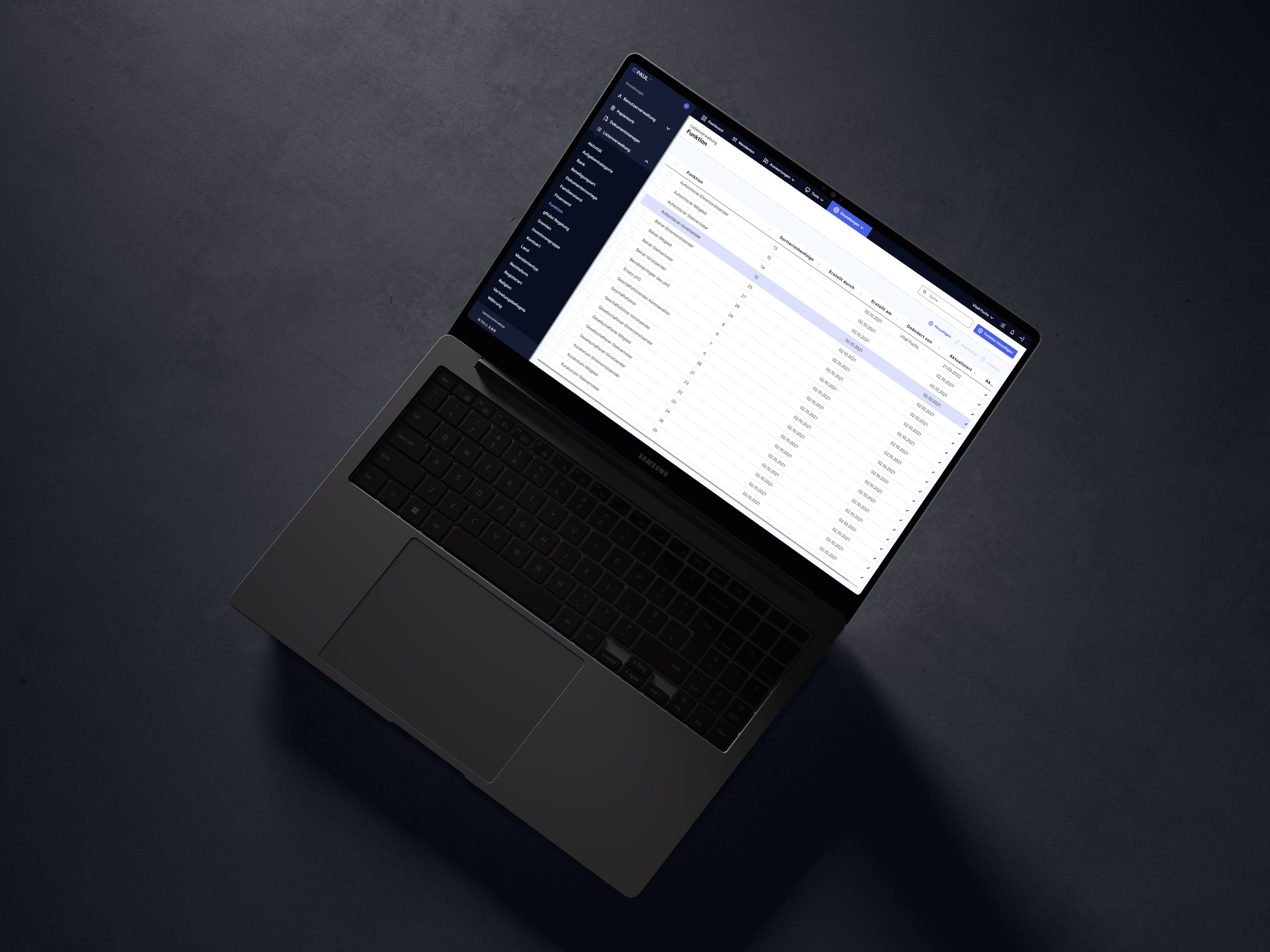 Laptop auf dunklem Tisch mit geöffnetem Tabellenblatt auf dem Bildschirm, verschiedene Daten sichtbar.
