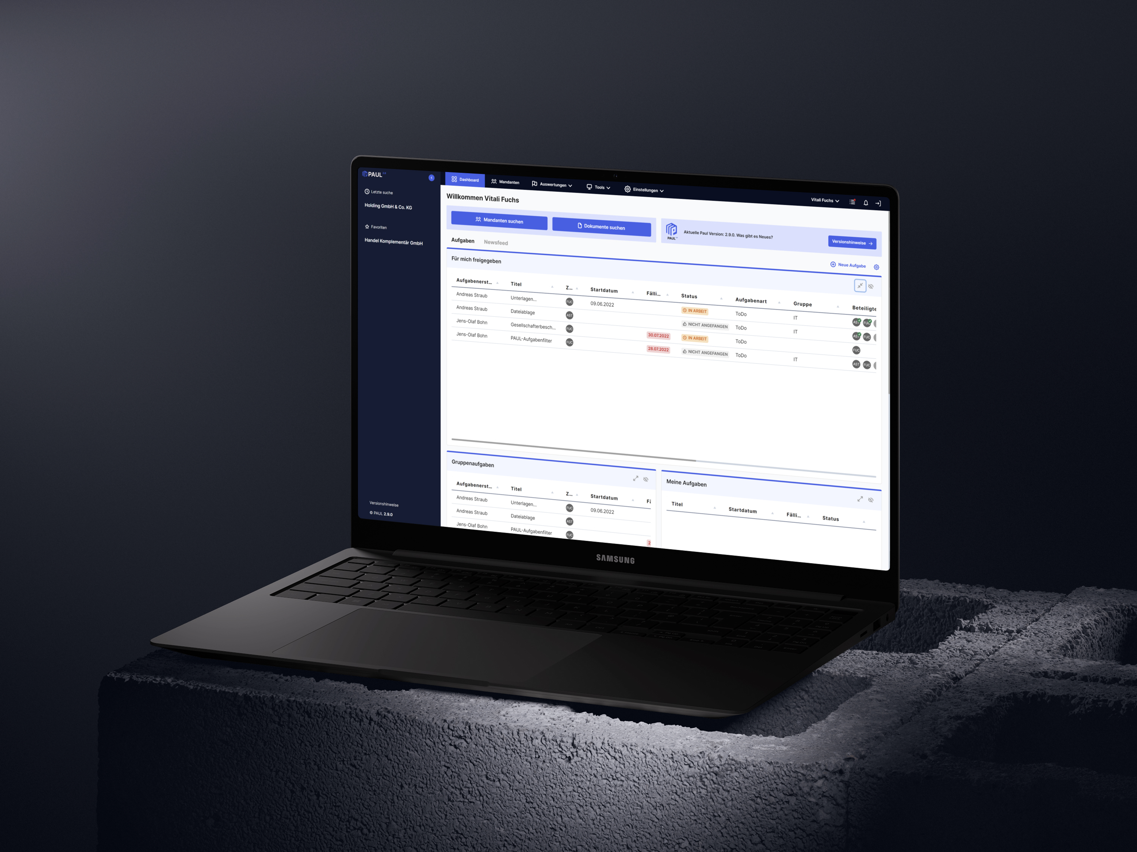 Laptop zeigt Software-Dashboard, platziert auf einem Betonblock, dunkler Hintergrund.