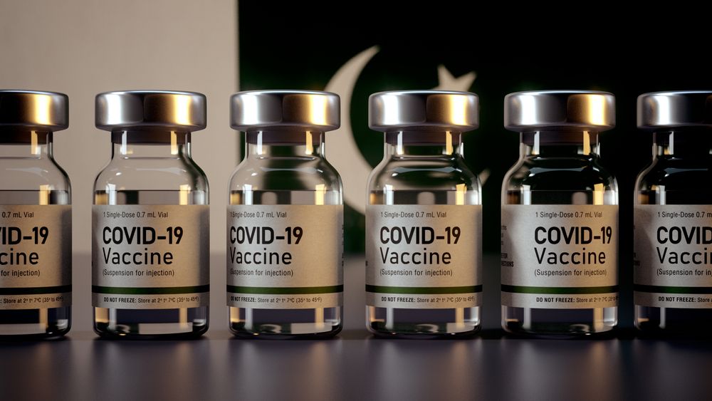An image of COVID-19 vaccines with the Pakistani flag behind them 