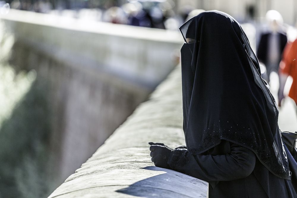 Image of a woman in a black niqab. 