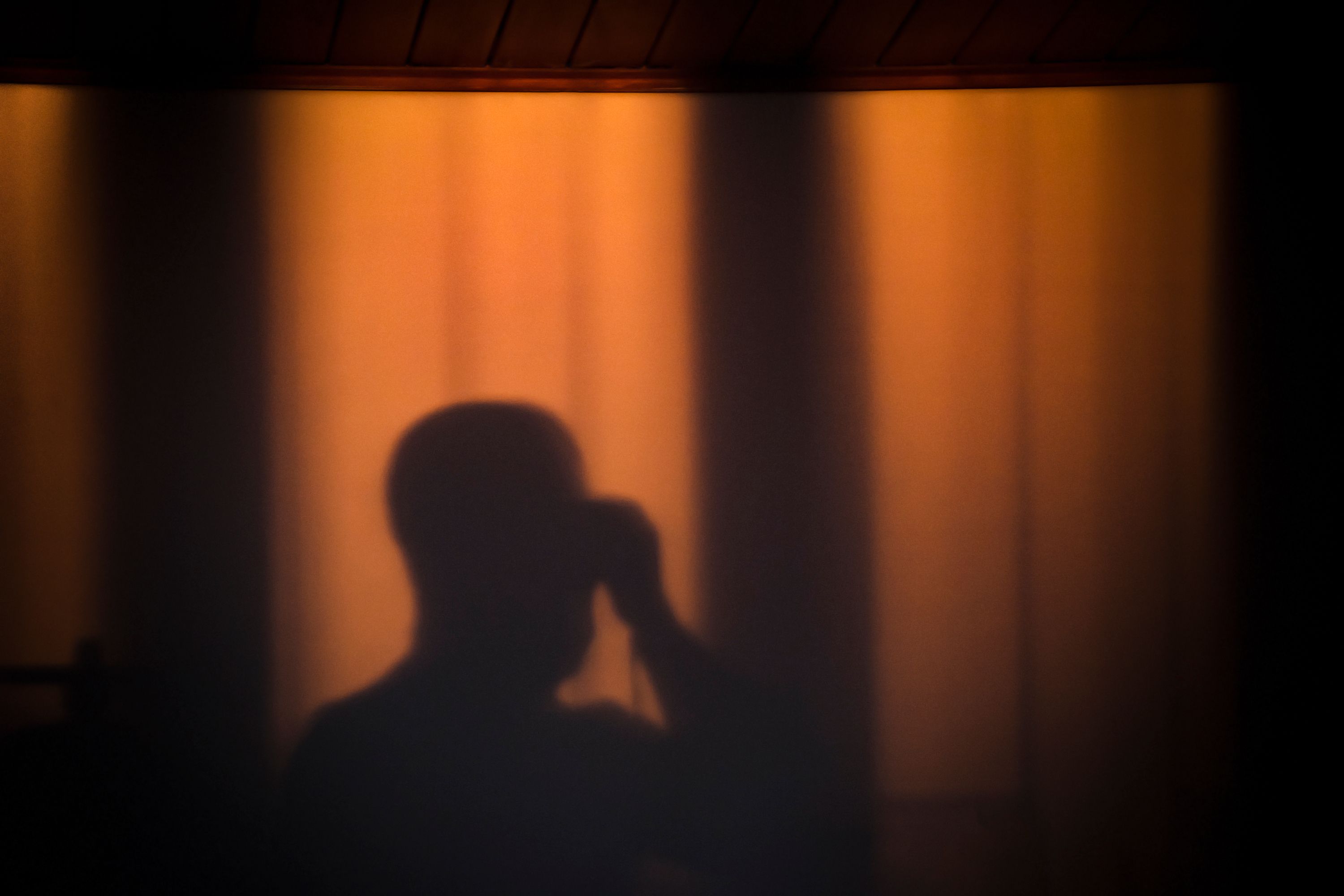 Image of a person in the shadows in orange light 