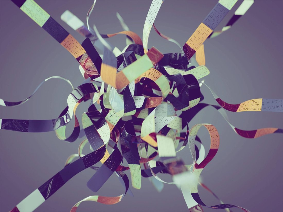 A tangled ball of multi-colored strips on a grey background.