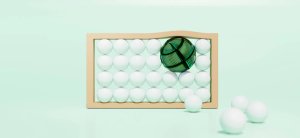 A large green sphere pushes smaller white spheres out of a tan frame.