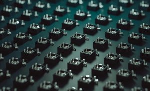 A grid of abstract boxes with metallic inserts on a dark teal background.