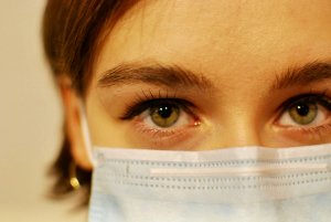 A closeup of a female in a healthcare mask.