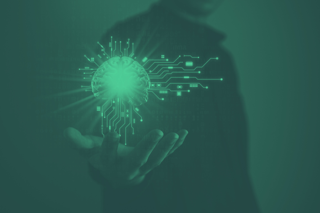 Green image of a digital image of a brain hovering over a person's hand