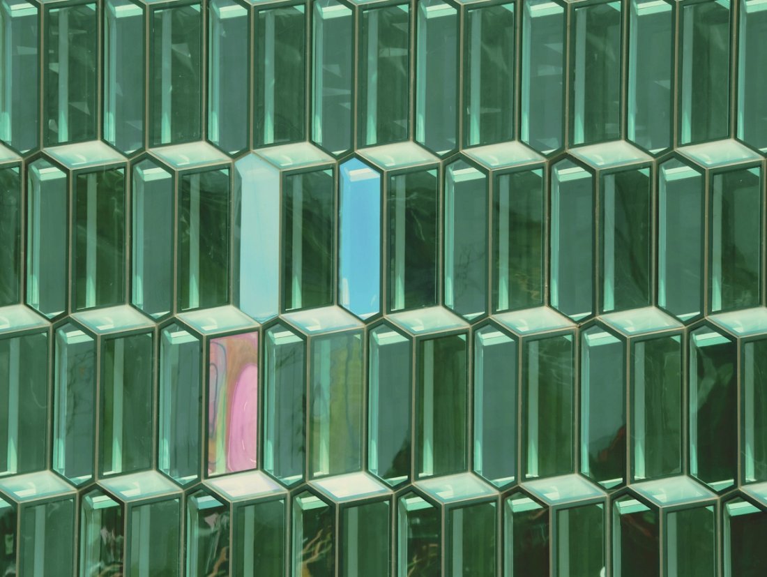Rows of abstract, glass-like elongated green hexagons.