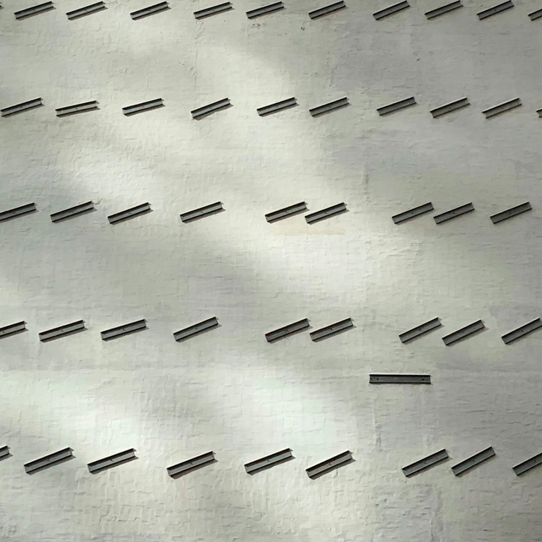 Coordinated rows of grey horizontal elements on a grey background.