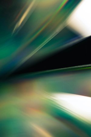 Green and white streaks of light on a dark background.