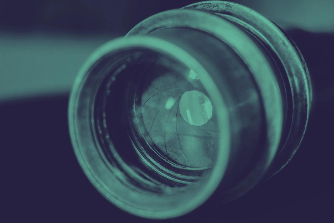 A closeup view of a green camera lens.