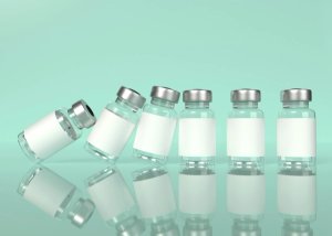 Clear medicine vials falling like dominos against a green background.