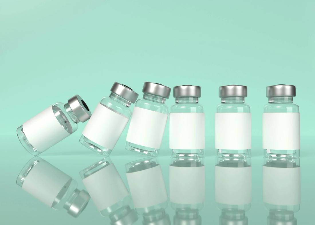 Clear medicine vials falling like dominos against a green background.
