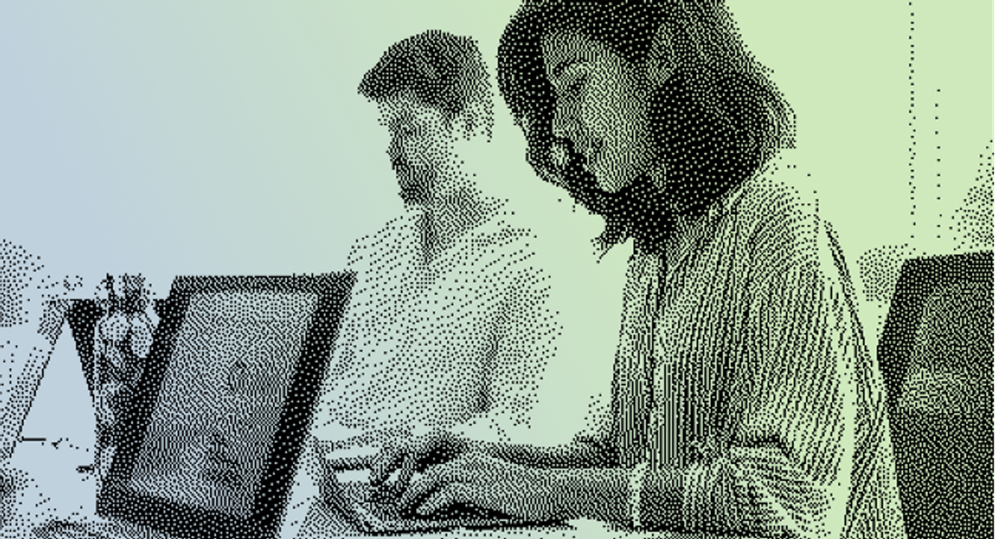 A pixelated image of two people working on laptops.
