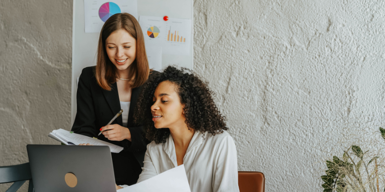 Women/coworkers looking at a laptop. Personalize Customer Experience.