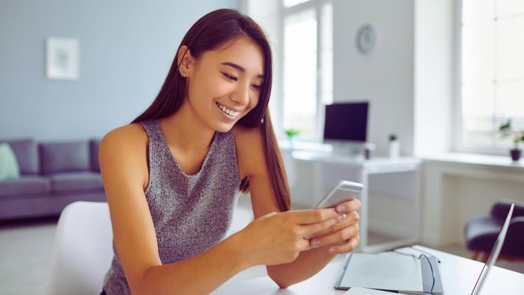 Women sitting with her phone interacting with Roccai