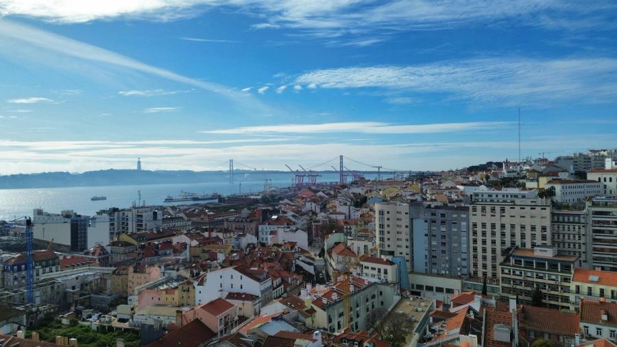 Lisbon's red rooftops overlook the Tagus River and distant suspension bridge