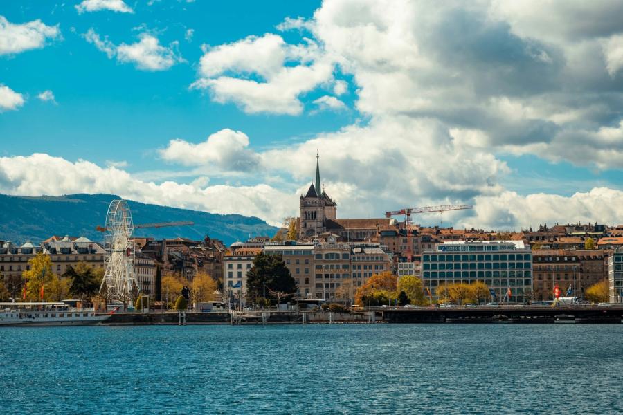 Geneva waterfront and rooftops beneath a partly cloudy sky