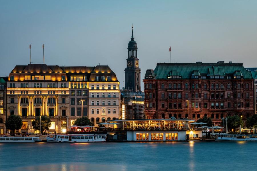 Hamburg waterfront buildings and clock tower illuminated at dusk