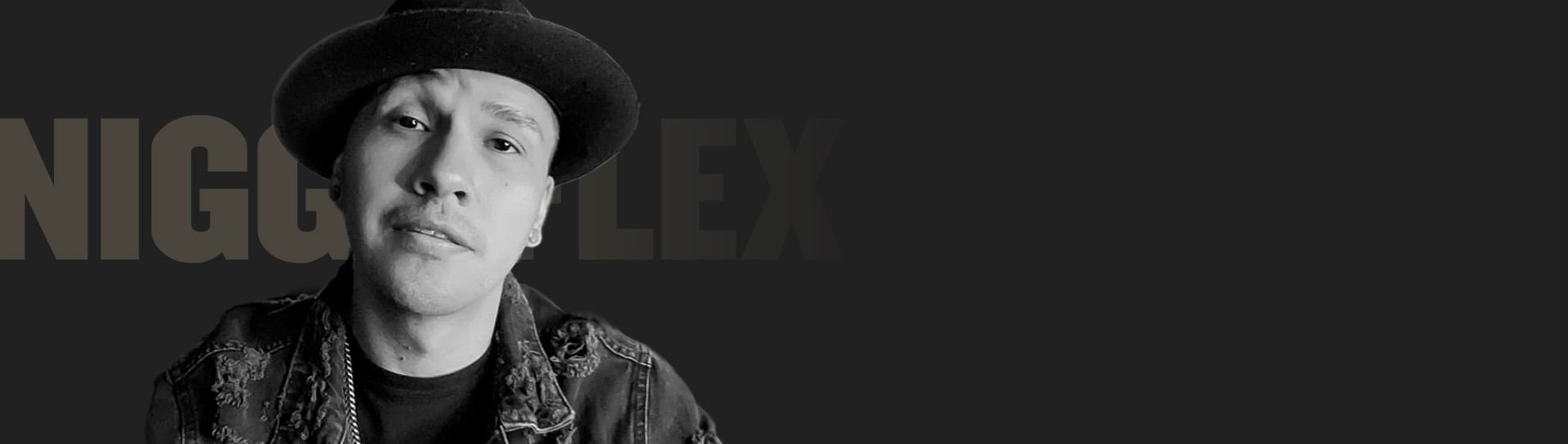 Nigga Flex, wearing a black hat, looking at the camera.