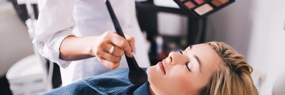 Professional makeup artist applying makeup to a client in a beauty salon setting.