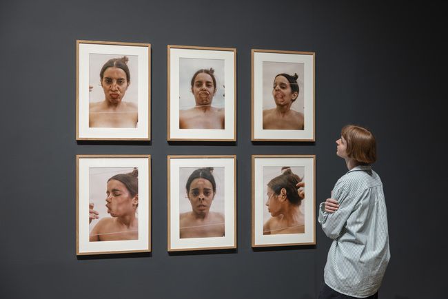 Six photographs show the artist pressing and distorting her face against glass