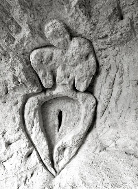 A female form carved into a limestone wall
