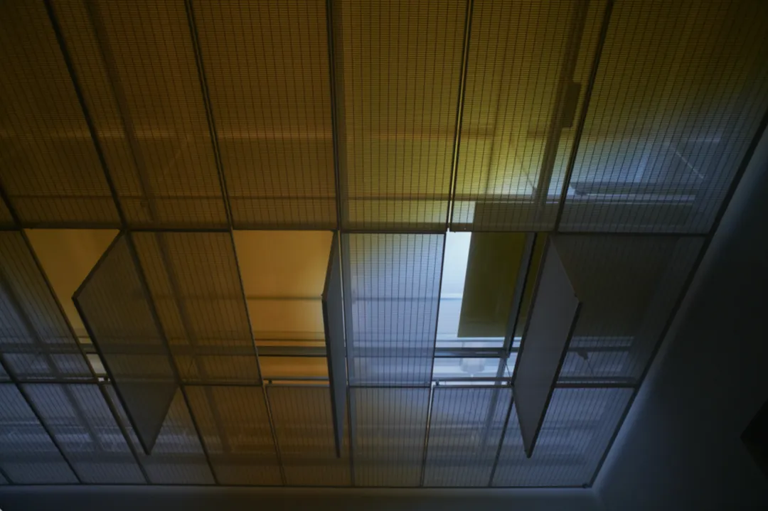 The aluminum panel of L’hésitant on a ceiling-mounted rail