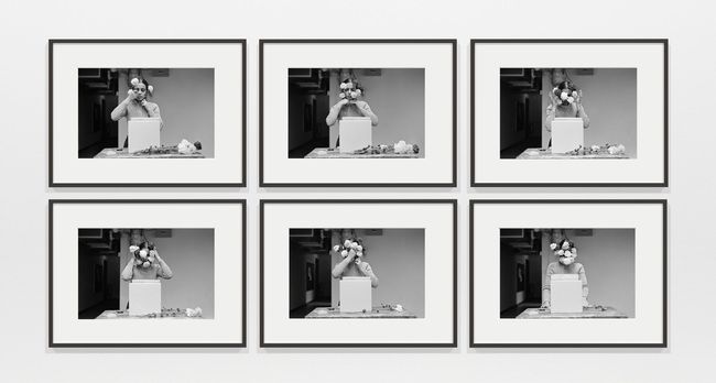 Six black-and-white photographs record the artist performing an action with flowers