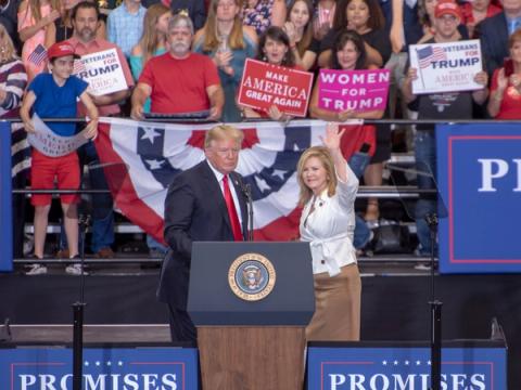 Marsha Blackburn waves beside President Donald J. Trump at a rally in Nashville, Tennessee, May 29, 2018 (public domain photo via Wikimedia Commons)