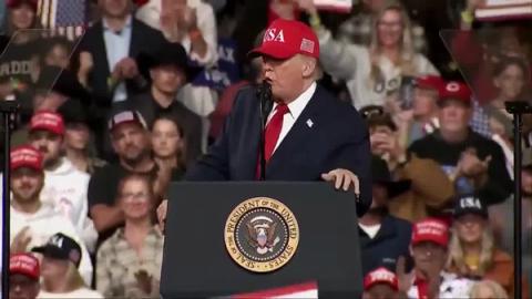 President Donald J. Trump gestures as he speaks at a lectern bearing the presidential seal at his rally in Montana, October 14, 2026 (still from Rapid Response 47 video)