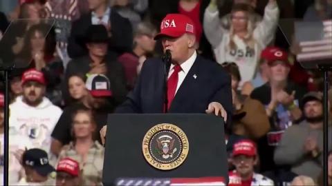 President Donald J. Trump, in front of a crowd that includes cowboy hats and American flags, speaks at a lectern bearing the presidential seal at his rally in Montana, October 14, 2026 (still from Rapid Response 47 video)