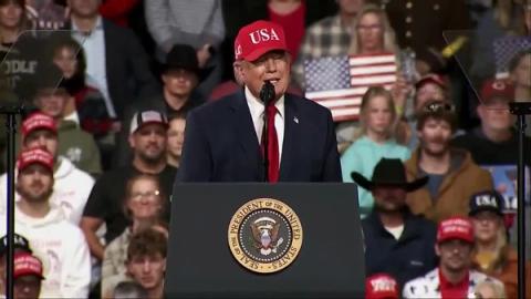 President Donald J. Trump, wearing a red USA cap, speaks at a lectern bearing the presidential seal at his rally in Montana, October 14, 2026 (still from Rapid Response 47 video)