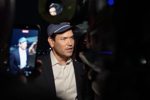Secretary of State Marco Rubio, wearing a ball cap, speaks with reporters as a phone records him at Joint Base Andrews, Oct. 17, 2026. Secretary Rubio on X, Oct. 17, 2026: “Just departed for Uzbekistan and India to continue securing the Trump Administration's economic opportunities for our nation.”
