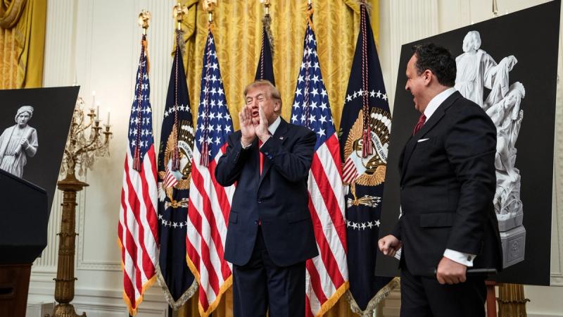 President Trump at the White House Columbus Day celebration with Christopher Columbus statue posters and presidential flags, October 2026 (Official White House photo)