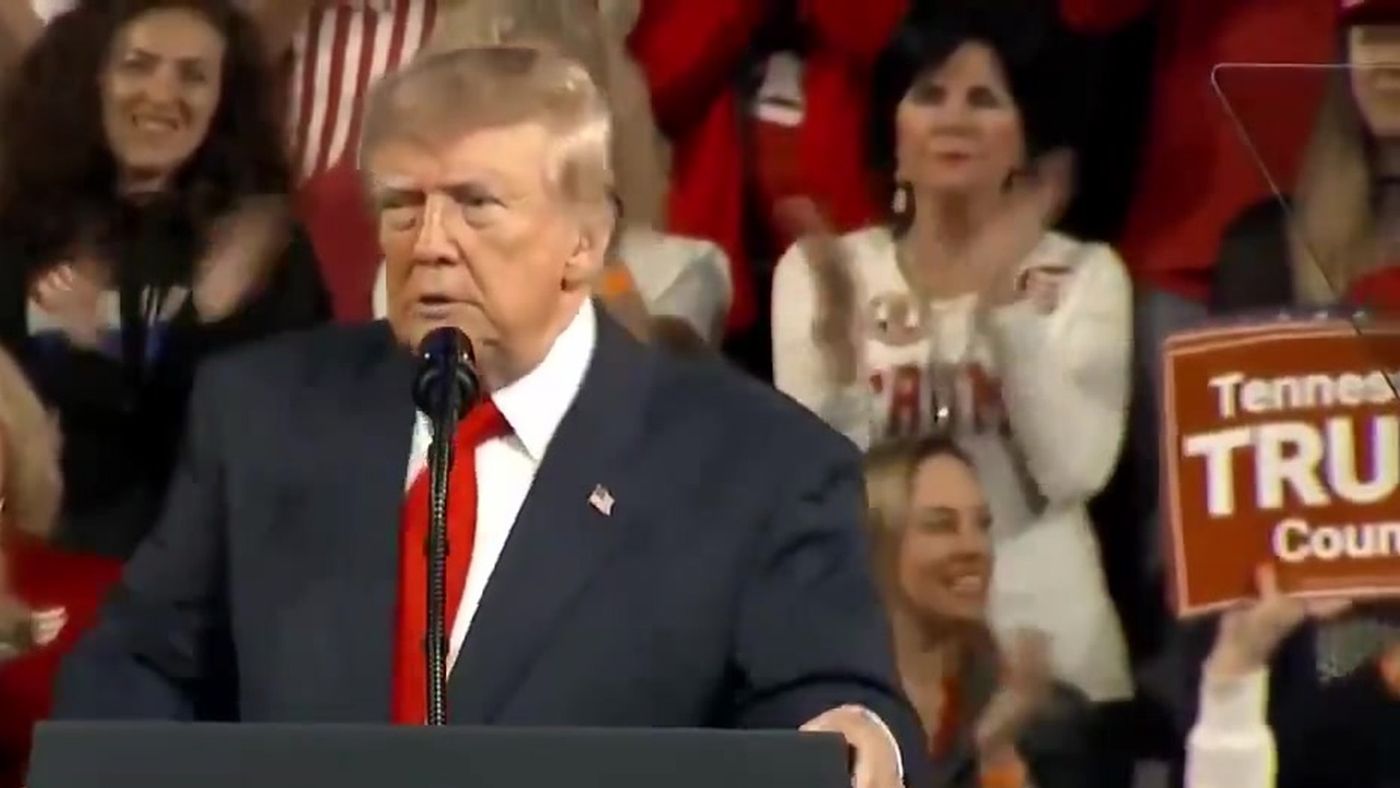 President Trump speaks at a lectern as rally attendees applaud behind him and a supporter holds a Tennessee Trump sign, at his rally in Tennessee, October 10, 2026 (still from Official White House video)