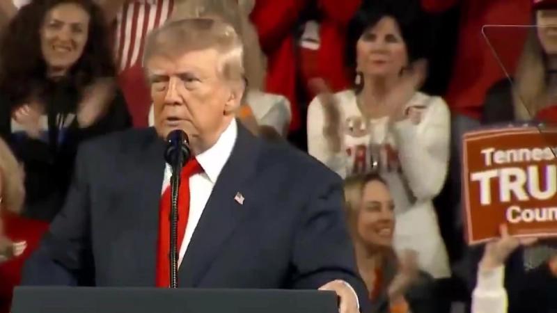President Trump speaks at a lectern as rally attendees applaud behind him and a supporter holds a Tennessee Trump sign, at his rally in Tennessee, October 10, 2026 (still from Official White House video)