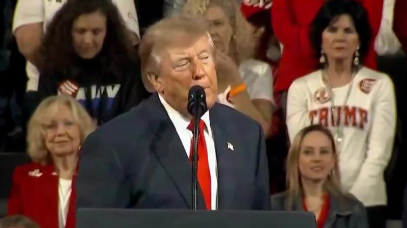 President Trump speaks at the presidential lectern as supporters, including one in a TRUMP shirt, stand behind him at his rally in Tennessee, October 10, 2026 (still from Official White House video)